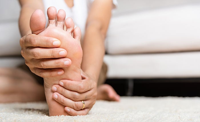 Woman-holding-foot-in-pain